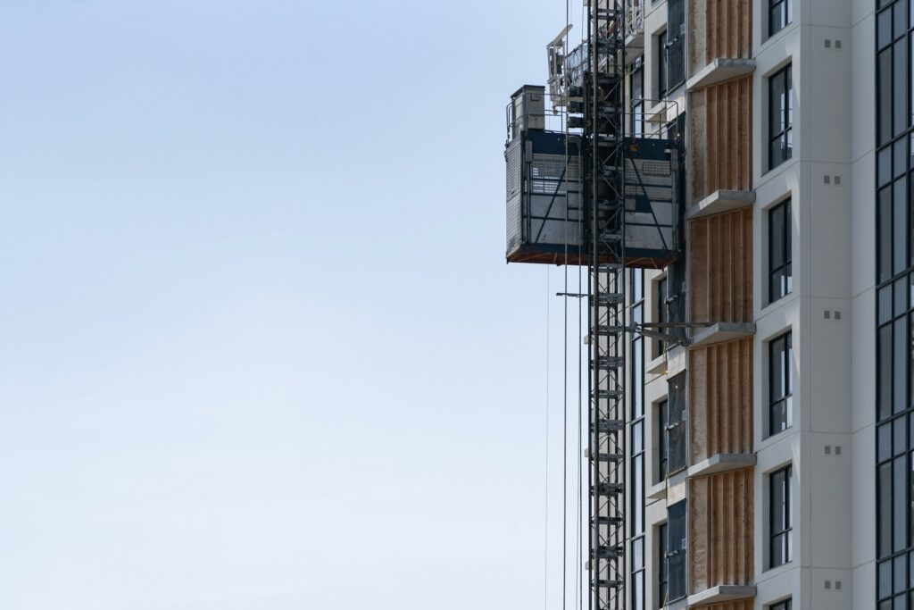 Image d'un ascenseur  sur un immeuble en travaux dans un ciel bleu